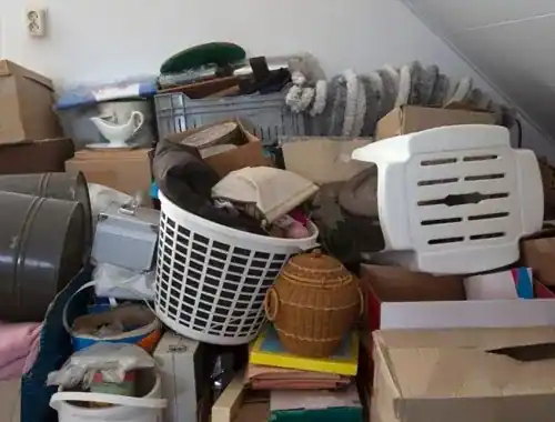 Vollgestellter Dachboden unter einer Dachschräge mit Kartons, Körben und Hausrat