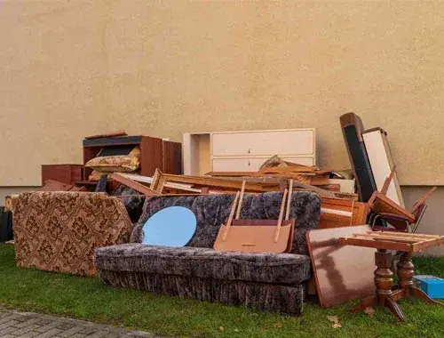 Alte Couch, Schränke und Tische, zur Abholung an der Hauswand abgestellt